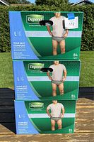 Three sealed boxes of Depend Fit-Flex men's underwear size Large stacked one on top of another on a wooden surface.