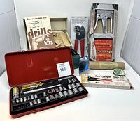 Overview photo showing Cummins Portable drill kit with operating instructions, Craftsman socket set in red case, Arrow staple gun kit, and other small items