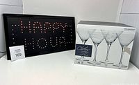 Happy Hour light-up sign next to boxed set of Mikasa Cheers martini glasses