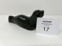 Side view of the Inuit seal sculpture showing carved details and polished surface.