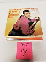 Stack of record covers led by Elvis Presley 'All Shook Up and Heartbreak Hotel' cover showing the top record in the set