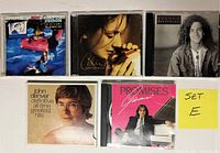 Front of 5 CDs in jewel cases showing album covers from Roy Orbison, Celine Dion, Kenny G, John Denver, and Giovanni with sticky note labeled 'SET E'.