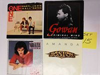 Front view of four 45 RPM records with original picture sleeves: Daryl Hall & John Oates One, Gowan Criminal Mind, Sheena Easton, and Boston Amanda.