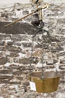 Side detail of the brass pan suspended by chains and the hanging steel hook.