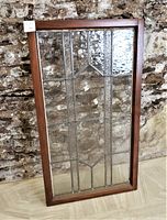 Front angled view of antique leaded glass window showing the entire geometric pattern and the wood frame with sturdy condition.