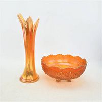 Pair of marigold carnival glass pieces showing full front view of vase and bowl with iridescent finish