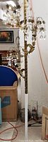 Lower midsection of lamp showing vertically fluted gilt metal pole and cherub figure attachment