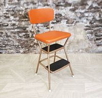 Front angle view showing metal frame, orange seat and backrest, two black steps, and white foot caps.