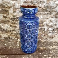 Full view of the tall cobalt blue vase showing the embossed vertical pattern and blue glossy glaze.