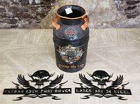Full image of the Harley-Davidson themed milk can with two metal skull signs.