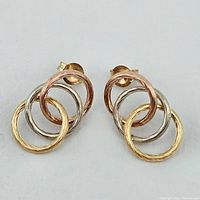 Front view of both earrings showing three interlocking hoops in yellow, rose, and white gold