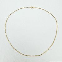 Top-down view of full length 10K yellow gold rope chain necklace laid flat on white background showing twisted rope link design and spring ring clasp.