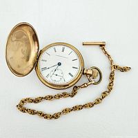 Open view of watch, chain and dime for scale