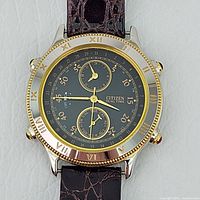 Front view of watch showing gold-tone Roman numeral bezel, black dial and subdials