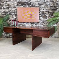 Frontal view showing floating top, central open storage compartment, side drawers, and geometric panel legs.