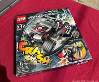 Front view of the boxed Lego 8140 Racers set on red surface showing the car image and branding.