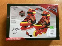 Box front showing image of red, black and yellow 2-in-1 kids skates and rollerblades with Disney Cars branding. Adjustable switcher skates, size Y12-2.
