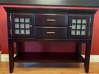 Full front shot of the dark wood buffet table showing overall structure with two drawers, two glass-paneled cabinets, and bottom shelf.