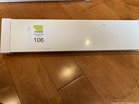 White rectangular box packaging labeled Mosslanda from IKEA with a Masold auction sticker numbered 106 placed on top, showing unopened condition.