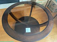 Top view of round coffee table showing glass inset and wooden frame