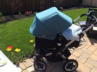 Side view of Bugaboo Buffalo stroller in bassinet mode on patio showing large underseat basket.