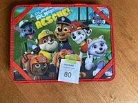 Top view of the Paw Patrol lap table showing colorful character graphic with text 'A Ruff Ruff Rescue!'