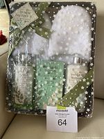 Photo of spa basket containing unopened eucalyptus mint spa products and white cozy slippers, all wrapped in clear star-patterned plastic with a green ribbon.