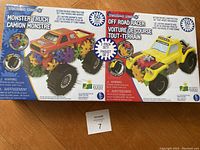 Front view of the unopened box showing both Monster Truck and Off Road Racer kits, highlighting their colorful designs and mechanic gear details on packaging.