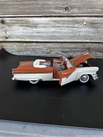 Side view of the diecast model with open driver's door and hood, showing exterior paint and opened parts.