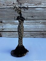 Front view of leopard print mannequin jewelry display stand showing hooks and lace dress detail