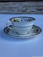 Side view of Royal Grafton teacup on matching saucer showing floral decoration and gold trim