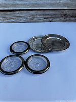 Four vintage silver serving plates; two with clear glass centers, two solid silver