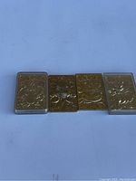 Four gold plated Pokemon cards arranged side by side on white background