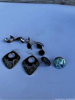 Photo showing the 4 pairs of vintage earrings on white background, silver and abalone shell materials visible.