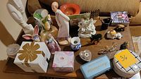 Overview of decorative figurines, small sculptures, vase, and boxes on a wooden coffee table