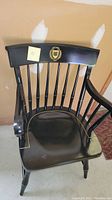 Black Yale University Captain's chair with Yale logo on backrest, showing the full front view including spindled back, armrests, and seat.