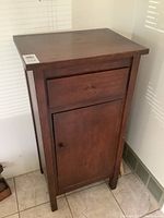Full view of the antique wooden cupboard showing top drawer and lower door in a corner of a room.