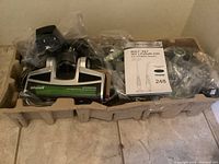Vacuum cleaner head and accessories cradled in molded cardboard packaging, vacuum parts wrapped in plastic bags.