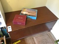 Closed wooden chest with games on top (puzzle and card deck)
