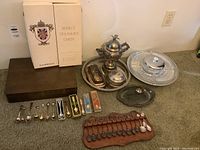 Overall grouping of boxes, trays, serveware pieces, wooden rack with spoons