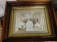 Full view of 1800s family portrait framed in wood with a gold inner border