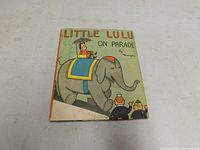 Front cover shot showing illustrated cover with Little Lulu riding an elephant and small tear at bottom left.