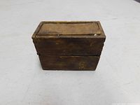 Closed view of the wooden punch set box showing aging and surface wear.