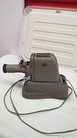 Side view of gray Viewiex antique projector showing lens, motor fan cooling vents and power cord.