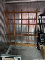 Front view of large bamboo shelf with multiple compartments, showcasing slatted bamboo design and spaced rectangular sections