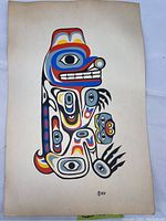 Full view of the bear design print in Pacific Northwest tribal style showing colorful stylized features on aged paper with some yellowed corners.