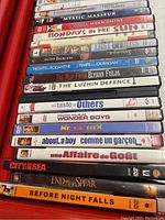 Stack of assorted DVD movies with visible titles such as Emotional Arithmetic, Mystic Masseur, Anger Management, Mondays in the Sun, and more.