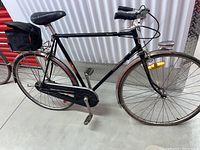 Side profile of the entire bike showing frame, wheels, saddle, rack and kickstand