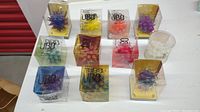 Full lot of 11 Valdesign UBO spiky light bulbs in assorted colors shown in packaging.