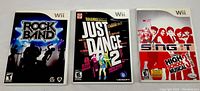 Photo of three Wii video games in original cases: Rock Band, Just Dance 2, High School Musical Sing It.
